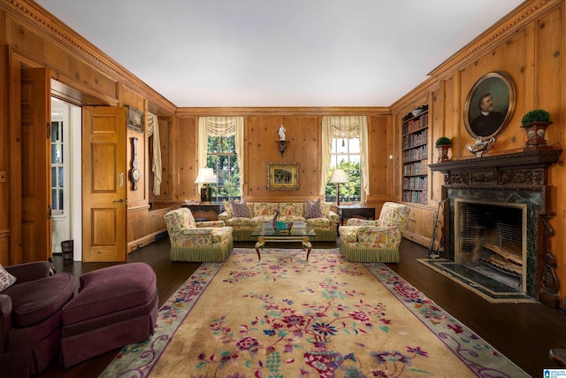 living room featuring built in features, wood walls, dark hardwood / wood-style flooring, and a premium fireplace