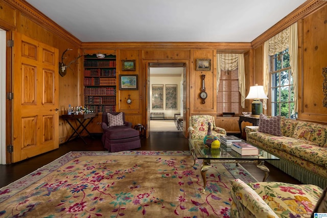 living room featuring ornamental molding, dark hardwood / wood-style flooring, and wooden walls