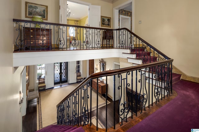 stairs with hardwood / wood-style flooring and ornamental molding