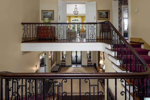 stairway with a towering ceiling and french doors