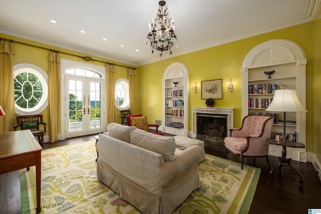 living room featuring crown molding, a chandelier, built in shelves, and hardwood / wood-style flooring