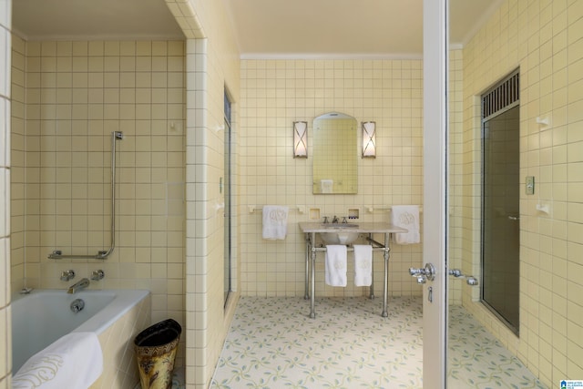 bathroom with tile patterned flooring, tile walls, shower with separate bathtub, and crown molding