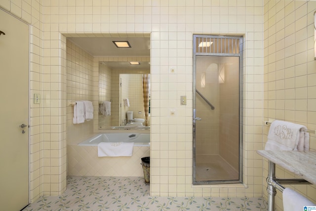 bathroom with plus walk in shower, tile walls, and tile patterned floors