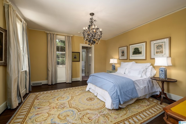 bedroom with ornamental molding, an inviting chandelier, and dark hardwood / wood-style floors