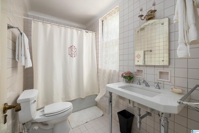 bathroom featuring tile patterned flooring, tile walls, decorative backsplash, and toilet