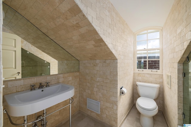 bathroom with tile patterned floors, sink, tile walls, and toilet