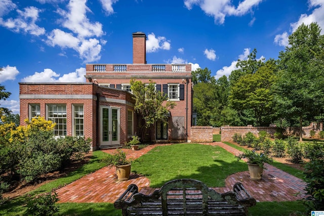 rear view of property with french doors and a yard