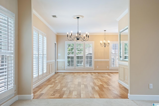 unfurnished dining area featuring an inviting chandelier, light hardwood / wood-style floors, and ornamental molding