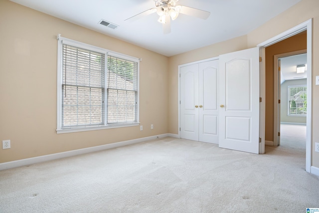 unfurnished bedroom with a closet, ceiling fan, and light colored carpet