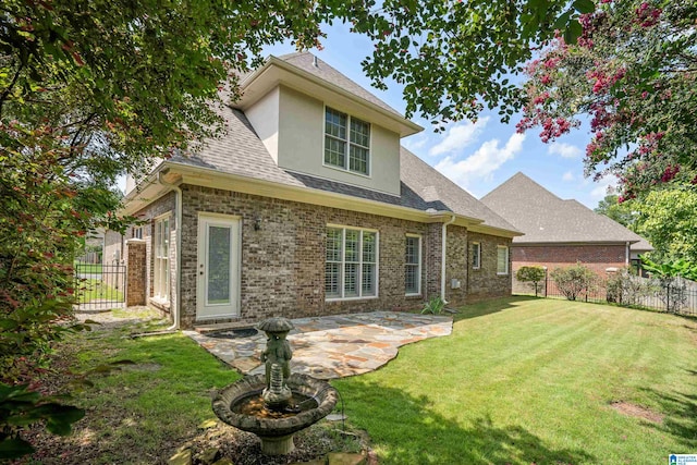 rear view of property with a patio area and a lawn