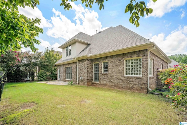 rear view of house featuring a patio and a yard