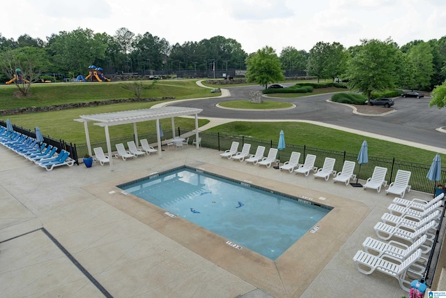 view of pool with a playground and a lawn