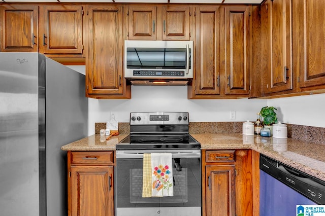 kitchen featuring stainless steel appliances and light stone counters