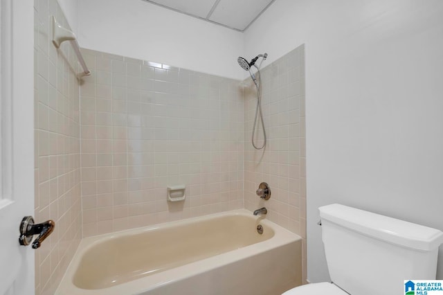 bathroom with toilet and tiled shower / bath