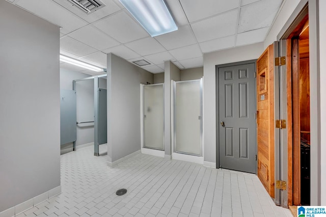 bathroom featuring an enclosed shower, a paneled ceiling, and tile patterned floors