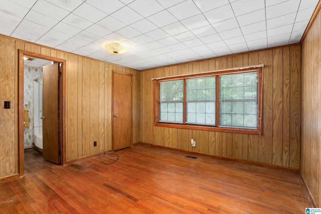 empty room featuring dark wood-type flooring and wood walls