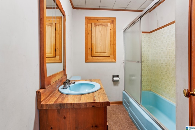 bathroom featuring vanity and bath / shower combo with glass door