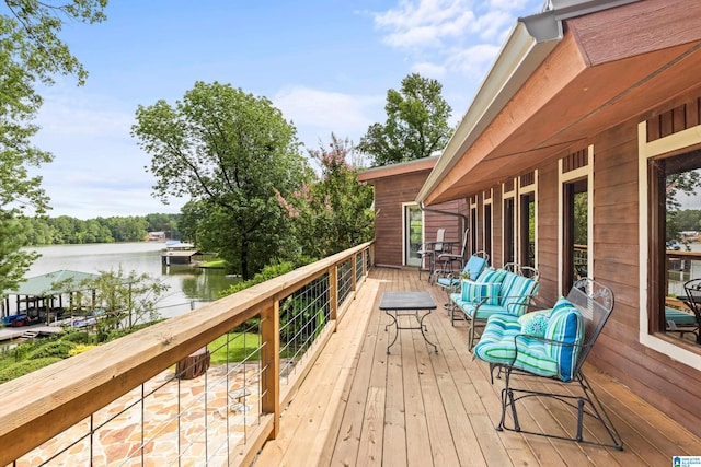 wooden deck with an outdoor living space and a water view