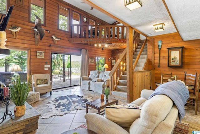 tiled living room with lofted ceiling with beams, a textured ceiling, and a healthy amount of sunlight