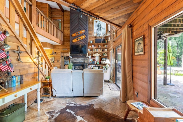 living room featuring wood walls, rail lighting, a fireplace, light tile patterned floors, and wood ceiling