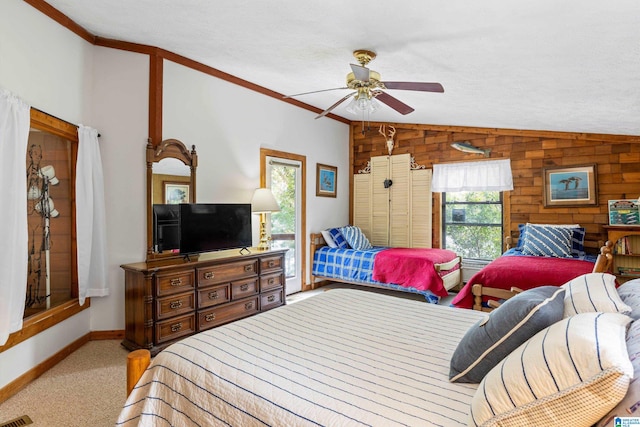 bedroom with ceiling fan, vaulted ceiling, wooden walls, and carpet flooring