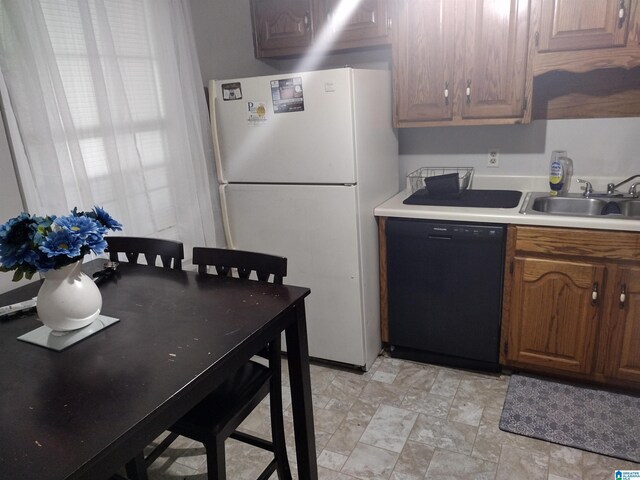 5315 Whisperwood Ct, Anniston, AL 36206 - kitchen with black dishwasher, freestanding refrigerator, a sink, light countertops, and stone finish flooring
