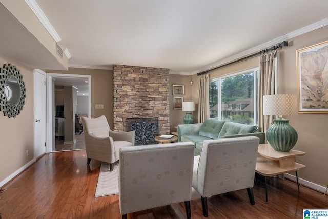 living room with a stone fireplace, crown molding, and wood-type flooring