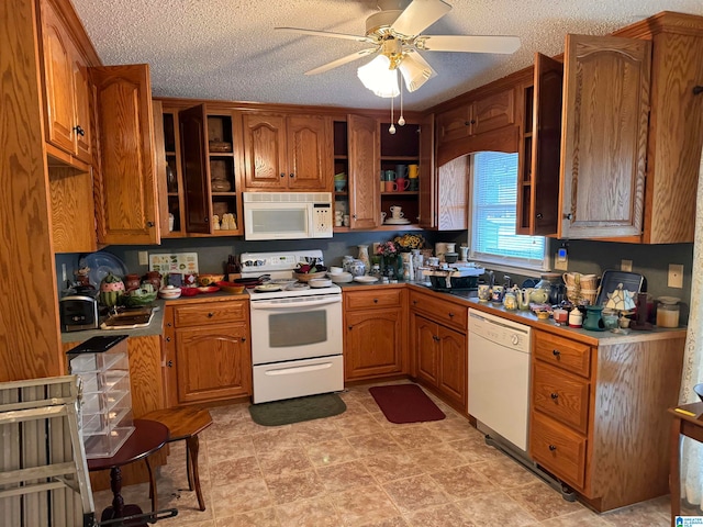 kitchen featuring a textured ceiling, white appliances, and ceiling fan