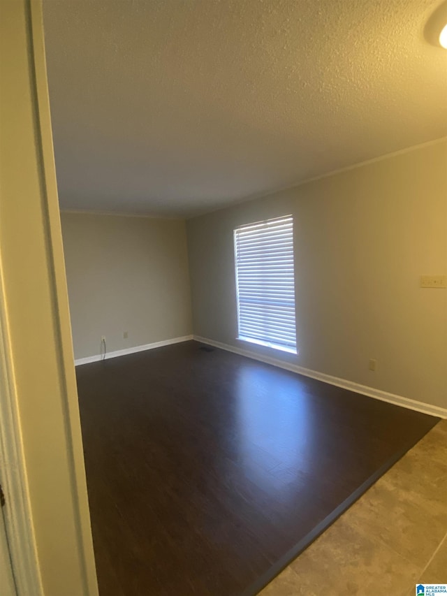 unfurnished room featuring hardwood / wood-style floors and a textured ceiling