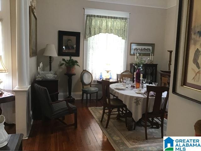 dining area with decorative columns and dark hardwood / wood-style floors