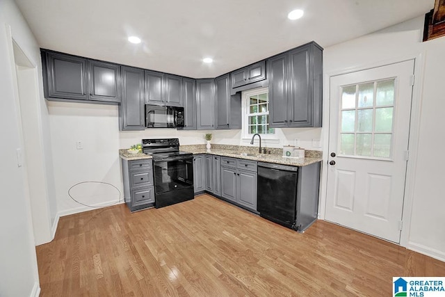 kitchen featuring recessed lighting, gray cabinetry, light wood-style floors, a sink, and black appliances