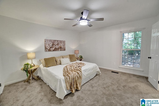 bedroom with a ceiling fan, light colored carpet, visible vents, and baseboards