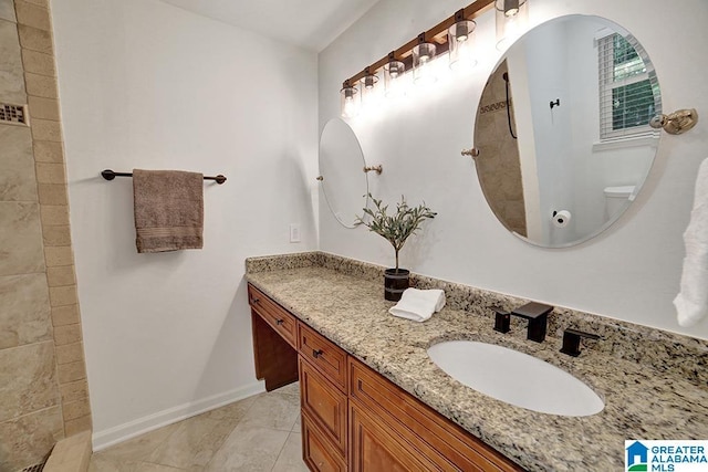 bathroom with baseboards, vanity, and toilet