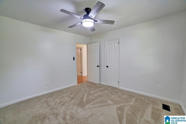 unfurnished bedroom with ceiling fan, carpet floors, visible vents, and baseboards