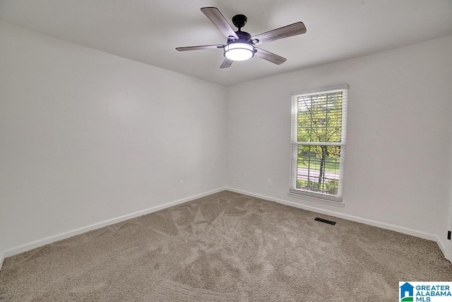 unfurnished room featuring carpet floors, a ceiling fan, visible vents, and baseboards