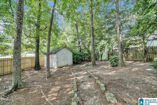 view of yard featuring a storage unit, an outdoor structure, and a fenced backyard