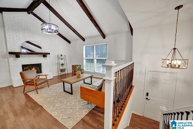 living area with a brick fireplace, wood finished floors, and an inviting chandelier