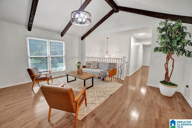 living room with lofted ceiling with beams, light wood-type flooring, baseboards, and a notable chandelier