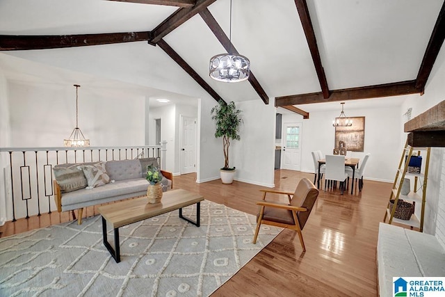 living room with lofted ceiling with beams, baseboards, a notable chandelier, and wood finished floors