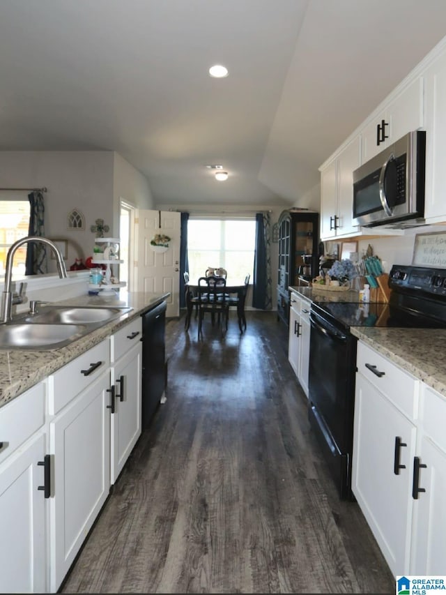 kitchen featuring dark wood-type flooring, white cabinetry, light stone counters, sink, and black appliances