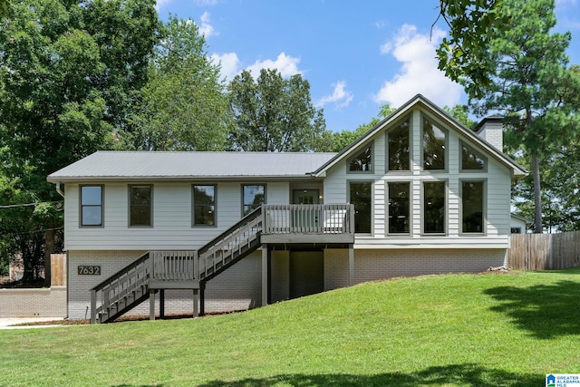 view of front of home with a deck and a front yard