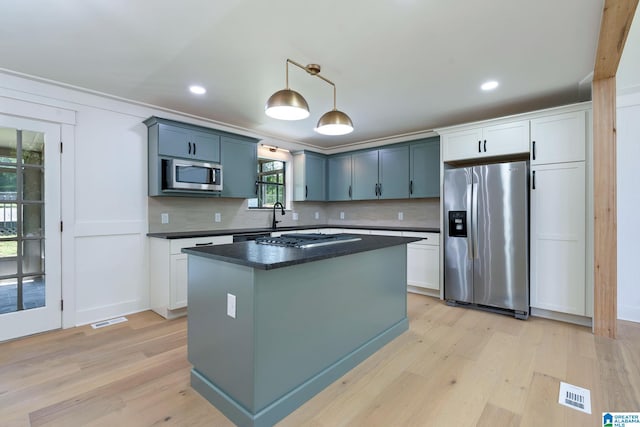 kitchen featuring white cabinetry, a center island, appliances with stainless steel finishes, and light wood-type flooring