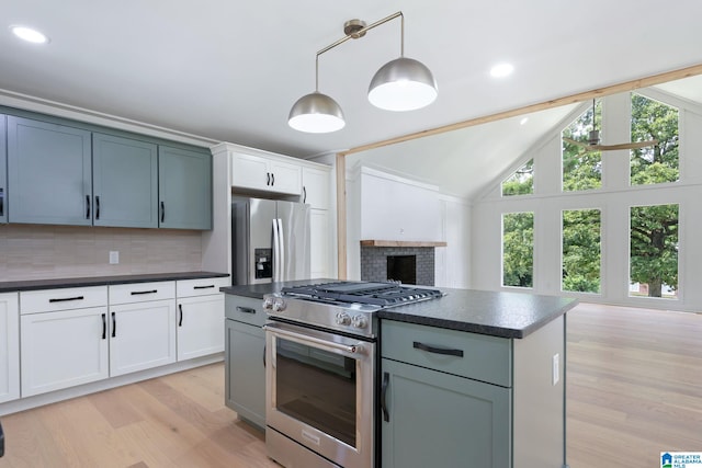 kitchen with decorative backsplash, stainless steel appliances, vaulted ceiling, and light wood-type flooring