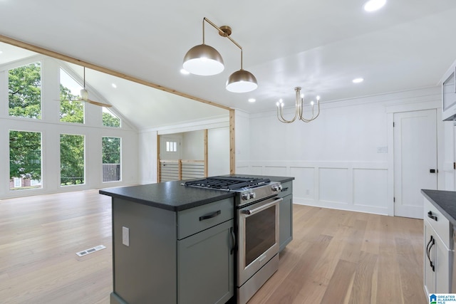 kitchen with an inviting chandelier, hanging light fixtures, light hardwood / wood-style floors, a center island, and high end stainless steel range