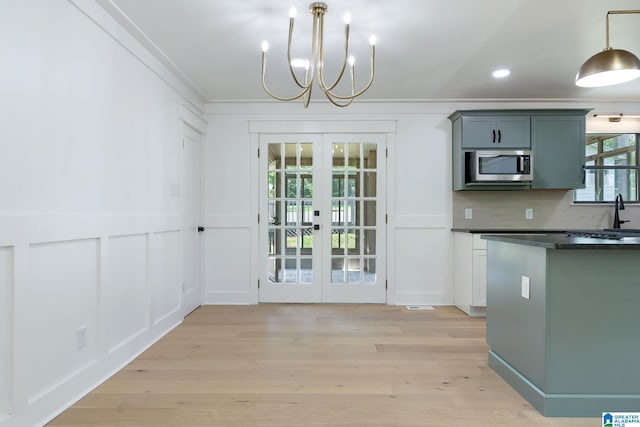 kitchen featuring decorative backsplash, french doors, light hardwood / wood-style flooring, and decorative light fixtures