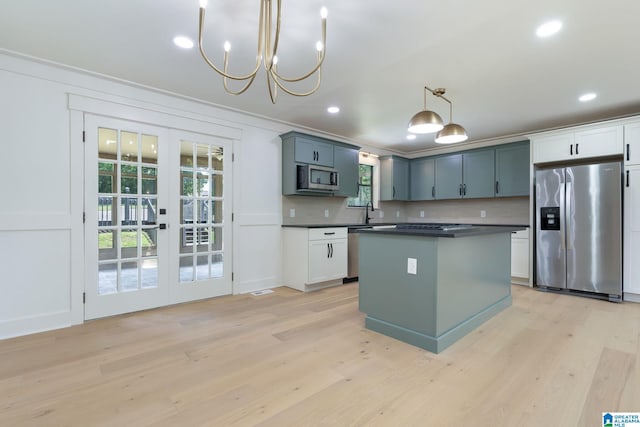 kitchen with stainless steel appliances, light hardwood / wood-style floors, and a wealth of natural light