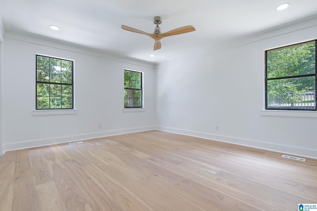 unfurnished room with crown molding, light wood-type flooring, and ceiling fan