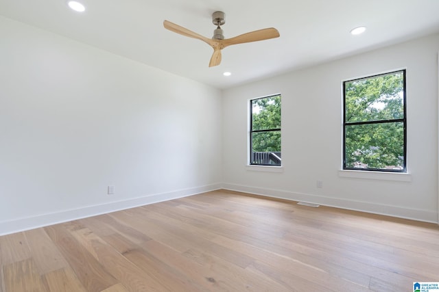 empty room featuring light hardwood / wood-style flooring, a healthy amount of sunlight, and ceiling fan