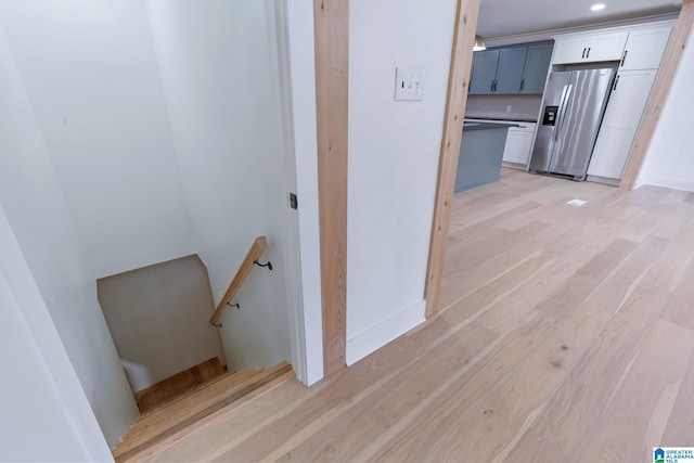 stairway with light hardwood / wood-style flooring