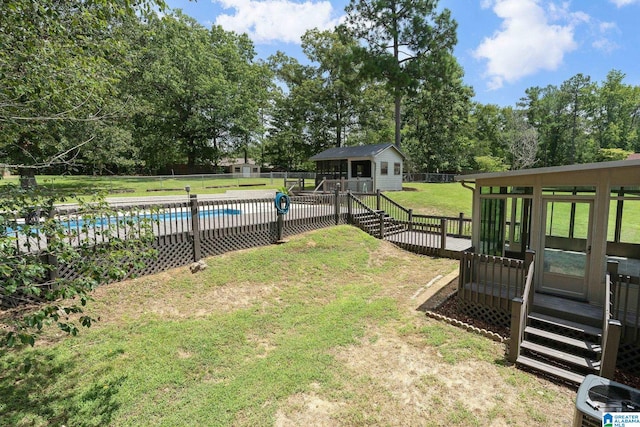 view of yard with a pool side deck and an outbuilding